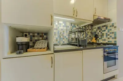 a kitchen with white cabinets and a sink at Stylish Studio Apt in Palm Views East PalmJumeirah in Dubai