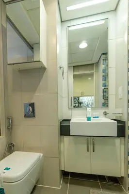 a bathroom with a sink and a toilet and a mirror at Stylish Studio Apt in Palm Views East PalmJumeirah in Dubai