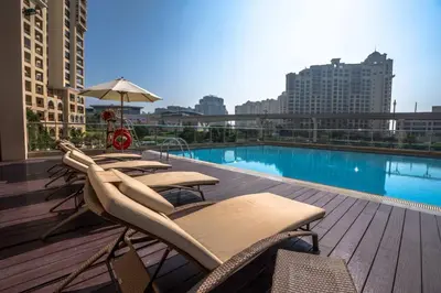 a deck with lounge chairs and a swimming pool on a building at Stylish Studio Apt in Palm Views East PalmJumeirah in Dubai