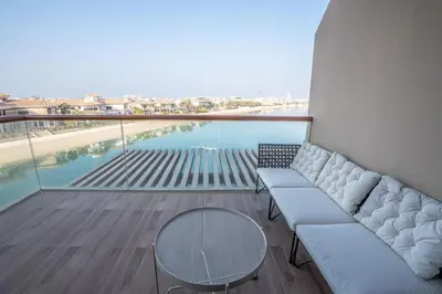 a balcony with a couch and a view of a pool at Stylish Studio Apt in Palm Views East PalmJumeirah in Dubai