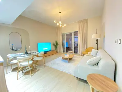 a living room with a couch and a dining room at Two-Bedroom Apartment with Prime Metro Access in Dubai