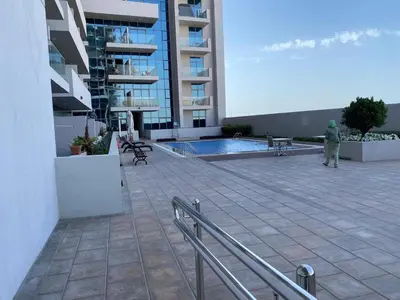a person standing in front of a large building at Two-Bedroom Apartment with Prime Metro Access in Dubai