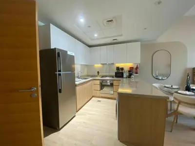 a kitchen with a stainless steel refrigerator and a sink at Two-Bedroom Apartment with Prime Metro Access in Dubai