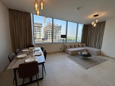 a living room with a table and a large window at Luxury 2-Bedroom Apartment in DIFC in Dubai