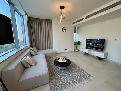 a living room with a couch and a flat screen tv at Luxury 2-Bedroom Apartment in DIFC in Dubai