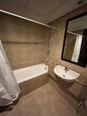 a bathroom with a bath tub and a sink at Luxury 2-Bedroom Apartment in DIFC in Dubai
