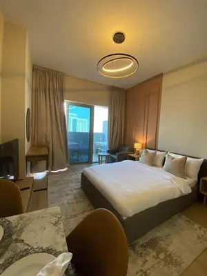 a hotel room with a bed and a living room at Furnished studio apartment next to metro in Dubai