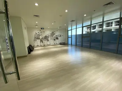 an empty room with paintings on the walls of a building at Furnished studio apartment next to metro in Dubai