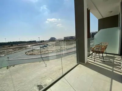 a balcony with a chair and a view of a highway at Cozy 1 Bedroom Apartment near Downtown in Dubai
