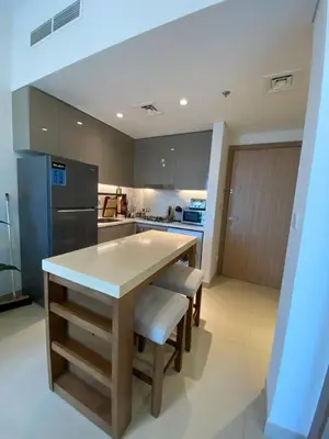 a kitchen with a table and chairs and a refrigerator at Cozy 1 Bedroom Apartment near Downtown in Dubai