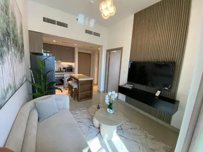 a living room with a couch and a television at Cozy 1 Bedroom Apartment near Downtown in Dubai