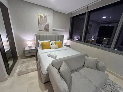 a bedroom with a bed and a couch and a window at Elegant Studio in Difc - Skyline Views, Pool, Gym in Dubai