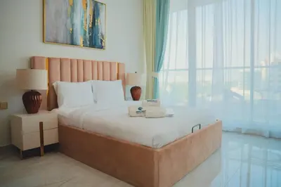 a bedroom with a large bed and a large window at Fully Furnished 2-Bedroom Apt in Gemz by Danube in Dubai