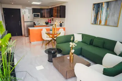 a living room with a green couch and a table at Fully Furnished 2-Bedroom Apt in Gemz by Danube in Dubai