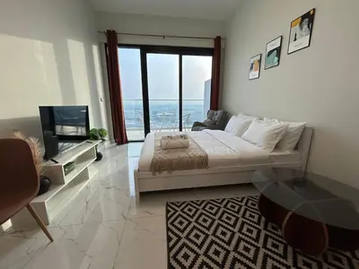 a large bedroom with a large bed and a television at Spacious 1BR - Alexis Tower 1 - Close to Metro in Dubai