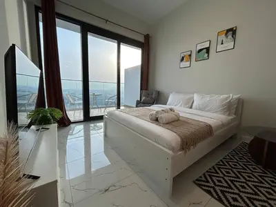 a bedroom with a large bed and a large window at Spacious 1BR - Alexis Tower 1 - Close to Metro in Dubai