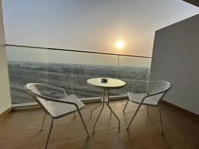 a table and two chairs in a room with a window at Spacious 1BR - Alexis Tower 1 - Close to Metro in Dubai