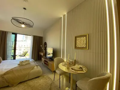a bedroom with a bed and a table and chairs at Cozy Studio Apartment with Balcony in Dubai