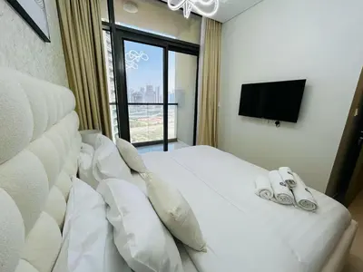 a bedroom with a white bed with two pairs of shoes on it at Modern 2bhk Apartment with Stunning City Views in Dubai