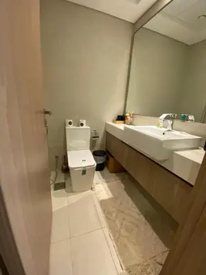 a bathroom with a sink and a toilet and a mirror at Stylish studio with Pool and Gym access. in Dubai