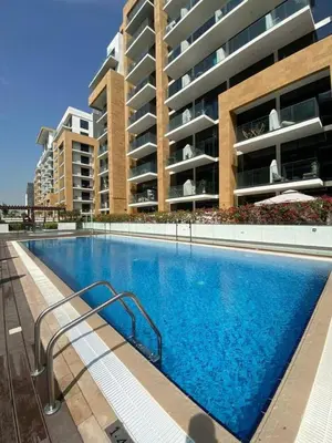 a large swimming pool in front of a building at Stylish studio with Pool and Gym access. in Dubai