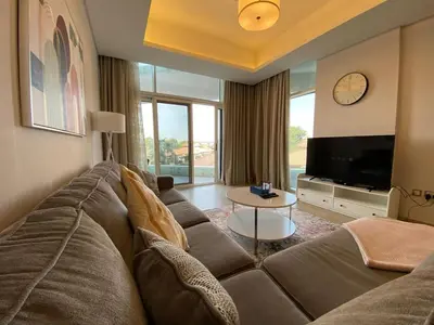 a living room with a large couch and a tv at Entire House in Palm Jumeriah with a Sea View in Dubai
