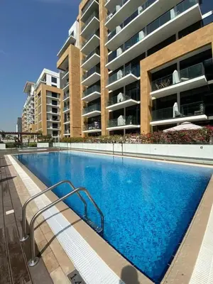 a swimming pool in front of a building at Studio Apartment with Pool and Gym Access in Dubai