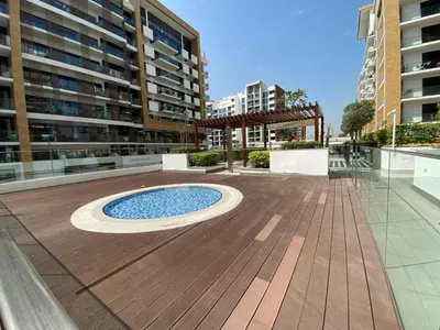 a courtyard with a pool in the middle of a building at Studio Apartment with Pool and Gym Access in Dubai