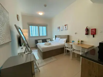 a hotel room with a bed and a table at Charming Studio Apartment in Jadaf in Dubai