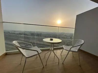 a table and two chairs in a room with a window at Modern Studio Apt in Jabel Ali Near Metro in Dubai