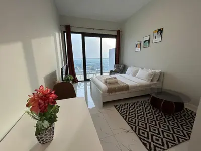 a living room with a bed and a table at Modern Studio Apt in Jabel Ali Near Metro in Dubai