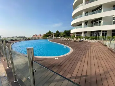a swimming pool in front of a building at Sea-facing 1BHK Apartment in Palm Jumeirah in Dubai