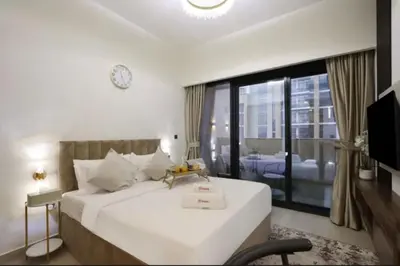 a bedroom with a large white bed and a large window at Fully Equipped Studio in Meydan in Dubai