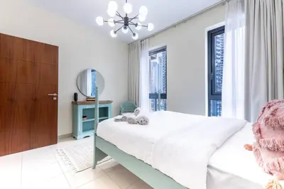 a white bedroom with a bed and a window at Modern and Cozy One BHK Apt - Heart of Downtown Dubai in Dubai