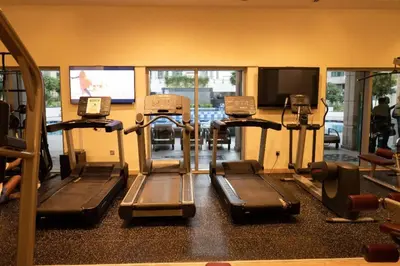 a gym with several tread machines and a tv at Modern and Cozy One BHK Apt - Heart of Downtown Dubai in Dubai