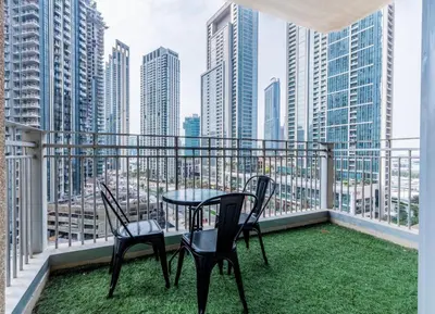 a table and chairs on a balcony with a view of the city at Modern and Cozy One BHK Apt - Heart of Downtown Dubai in Dubai