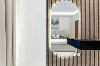 a mirror in a room with a bed and a bedroom at Modern 1BR Apt in Azizi Riviera 51 - Pool and Gym in Dubai