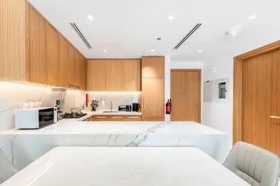 a kitchen with wooden cabinets and a white counter top at Modern 1BR Apt in Azizi Riviera 51 - Pool and Gym in Dubai