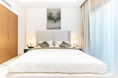 a bedroom with a large white bed with two lamps at Modern 1BR Apt in Azizi Riviera 51 - Pool and Gym in Dubai