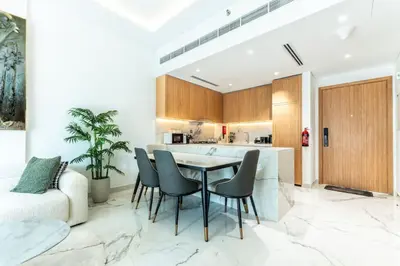 a kitchen with a table and chairs in a room at Modern 1BR Apt in Azizi Riviera 51 - Pool and Gym in Dubai