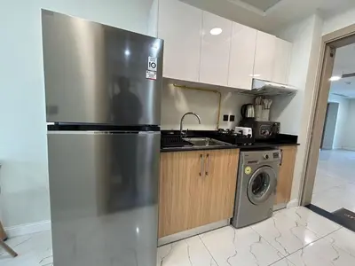a kitchen with a stainless steel refrigerator and a washing machine at Modern Studio Apt in Jabel Ali Near Metro in Dubai