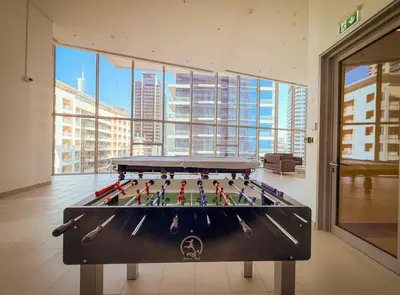 a pool table in a room with a large window at Luxury 43rd Floor 2 Bedroom Apartment in Dubai Marina in Dubai
