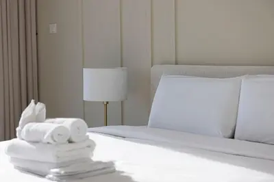a white bed with a pile of towels on it at Luxury 43rd Floor 2 Bedroom Apartment in Dubai Marina in Dubai