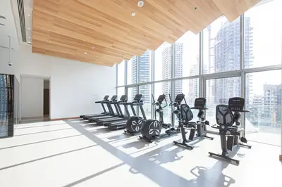 a gym with cardio equipment in a building with tall windows at Luxury 43rd Floor 2 Bedroom Apartment in Dubai Marina in Dubai