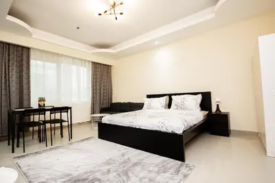 a bedroom with a bed and a table and a desk at Newly Furnished Studio at city tower building in Dubai