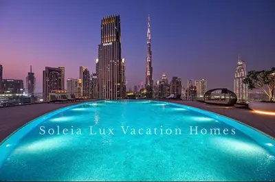a swimming pool in front of a city skyline at Luxury Condo near Burj khalifa in Dubai