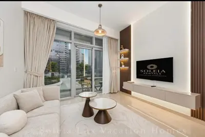 a living room with a couch and a tv at Luxury Condo near Burj khalifa in Dubai