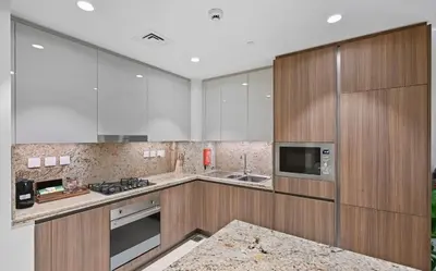 a large kitchen with wooden cabinets and a sink at Luxury Condo near Burj khalifa in Dubai