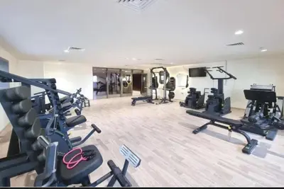 a gym with several treadmills and machines in a room at Luxurious cozy studio in Dubai