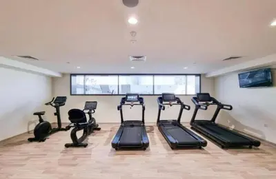 a gym with several tread machines in a room at Luxurious cozy studio in Dubai